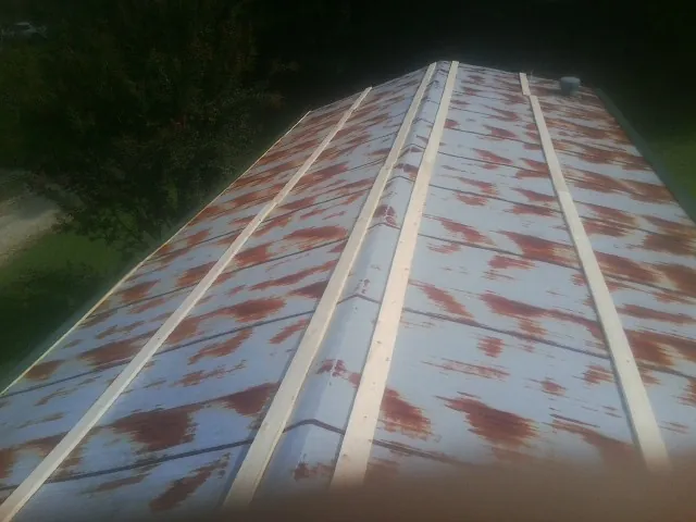 Rusted metal roof panels with new wood purlins before replacement — Storm Damage Roof Repair in Dodgeville by Roofing Brothers