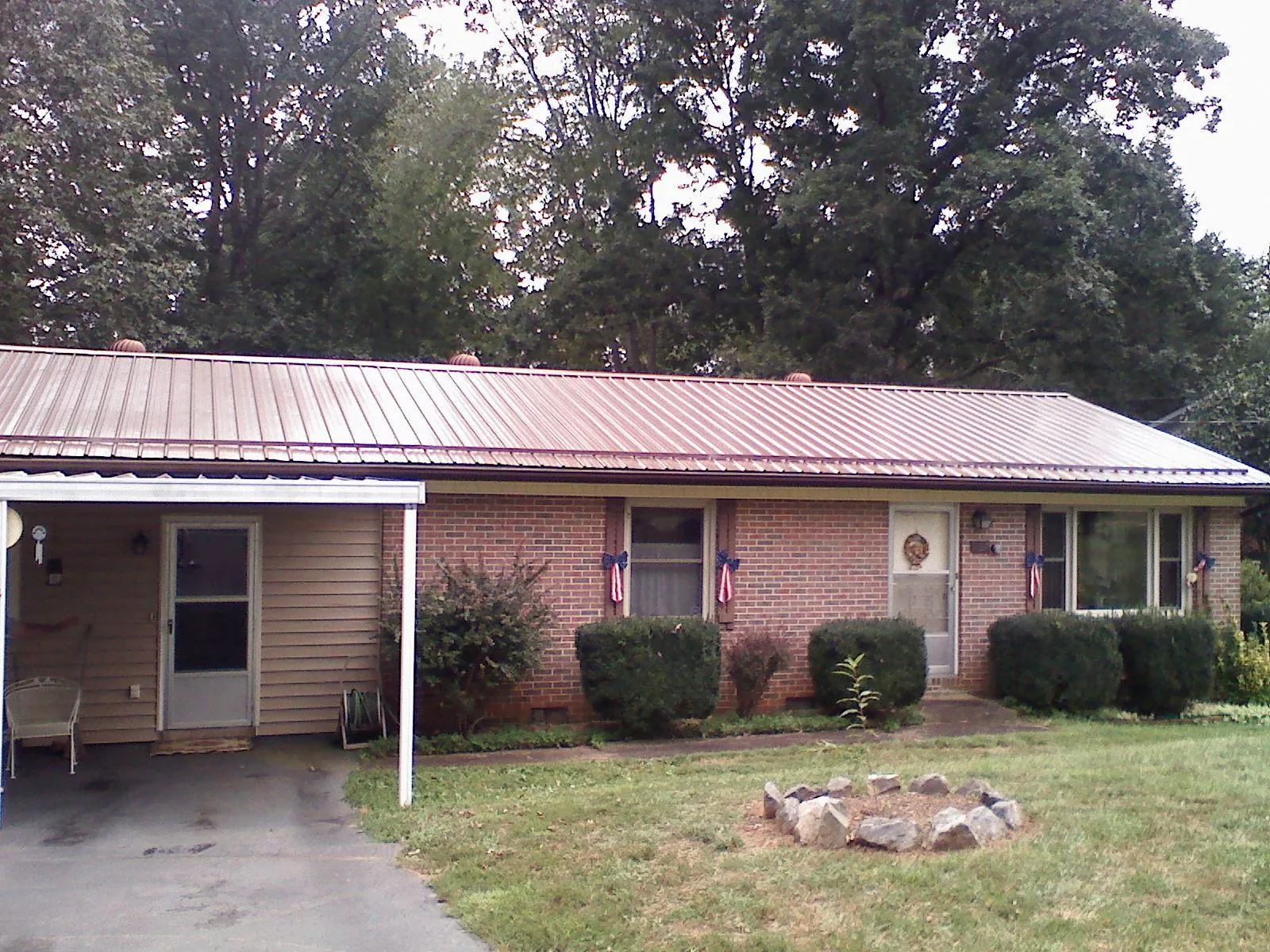 Bronze metal roof and carport on a brick ranch home — Roof Repair work by our crew in Dodgeville